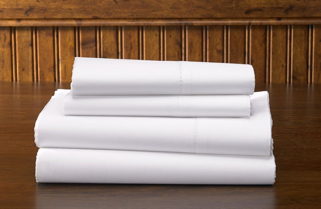 Folded white facility bed linen