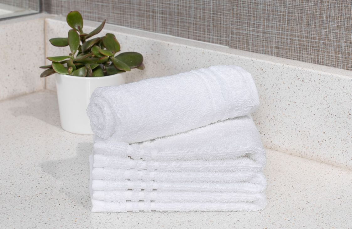 Stacked white hotel wash cloths